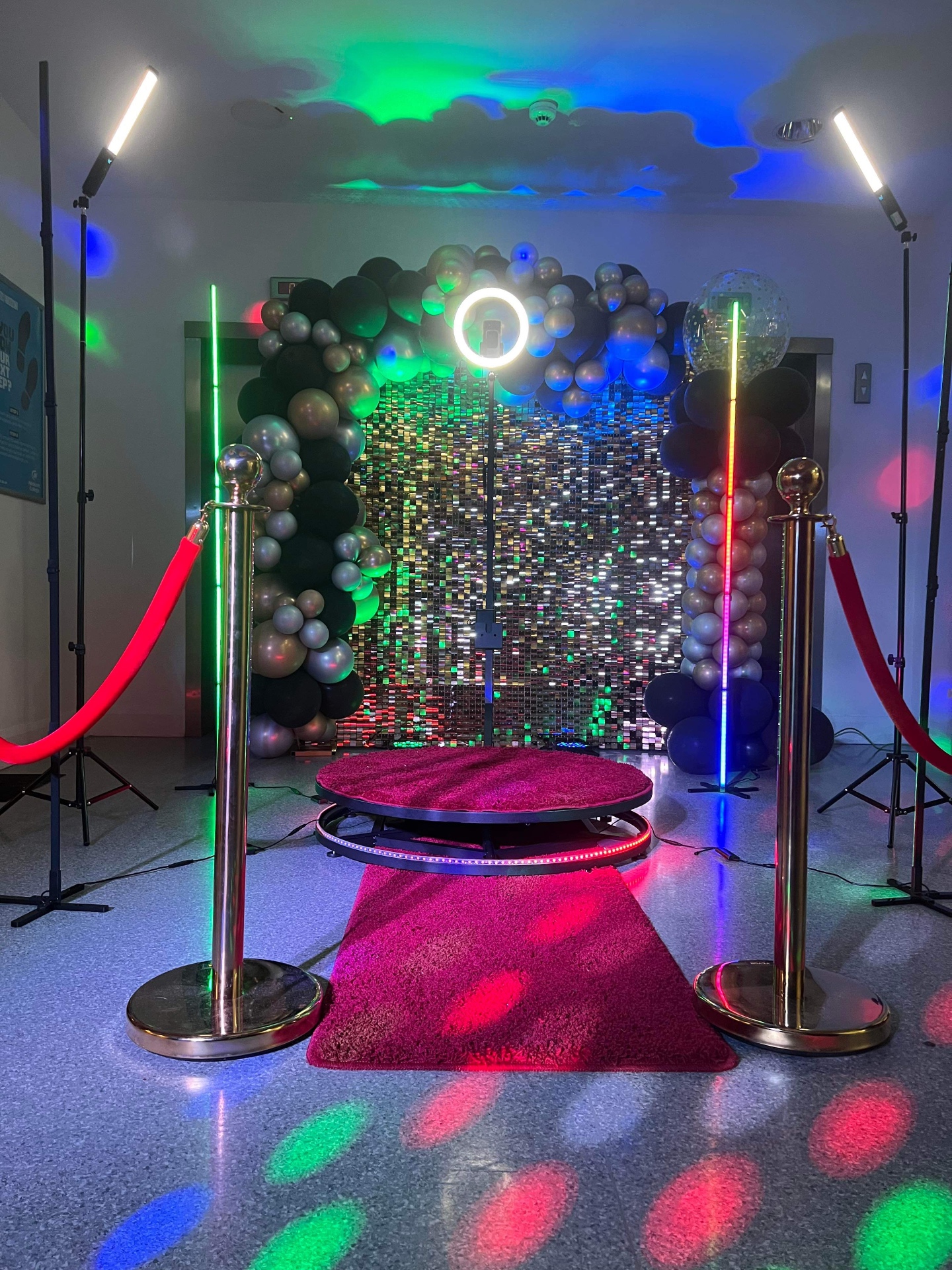 360 video booth setup with sequin backdrop and balloon garland at an event.